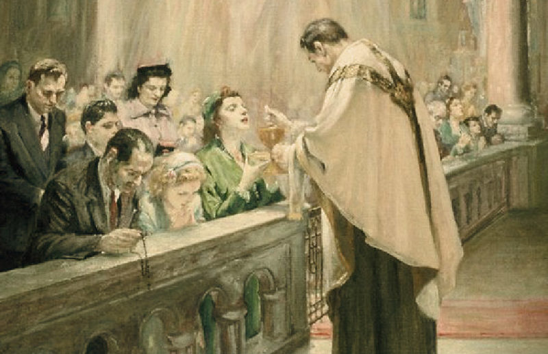 Priest giving Holy Communion to the faithful
