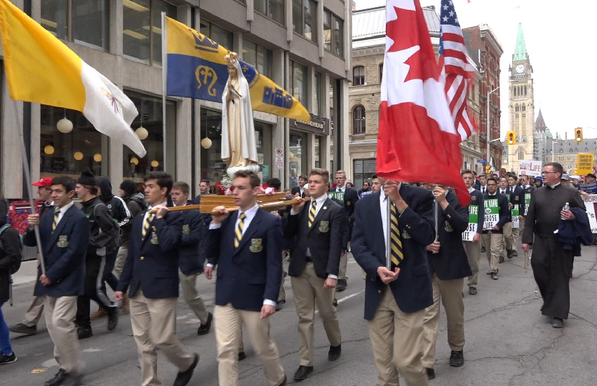 Boys marching with Pilgrim statue of Our Lady at the March for Life